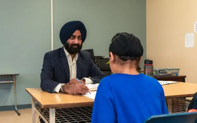 A counsellor talking with a child across a desk