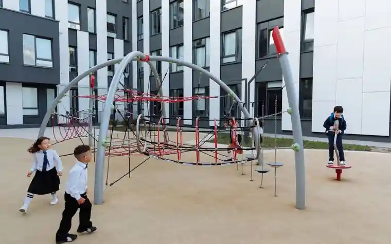 Children playing on climbing equipment in a school playground